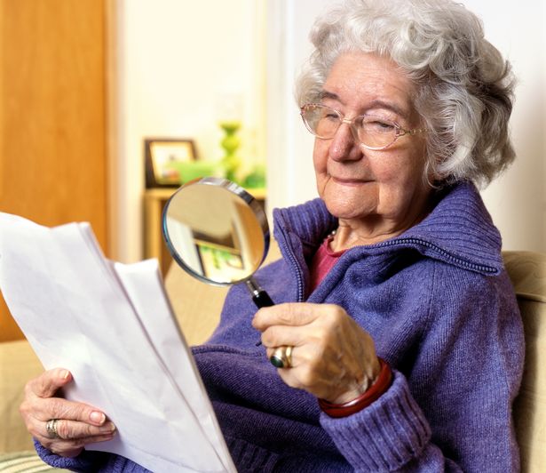 Retired lady reading with magnifying glass