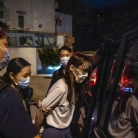 The pro-democracy activist Agnes Chow is led to a waiting van following her arrest at her home in Hong Kong on Aug. 10. Chow was released Saturday after serving about seven months in prison. | LAM YIK FEI/THE NEW YORK TIMES