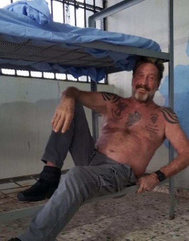 John McAfee showing his tattoos