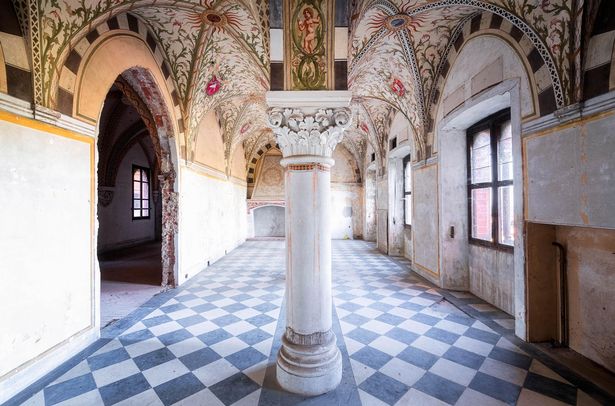 A hallway with mosaic ceilings and tiled floor