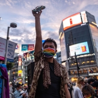 A participant gestures as he takes part in a rally organized by an activist group to support LGBTQ legislation in the Shibuya district of Tokyo on Sunday. | AFP-JIJI