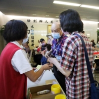 People inquire about registering for COVID-19 vaccinations at the Far Eastern Memorial Hospital in New Taipei City, Taiwan, on May 13. | BLOOMBERG