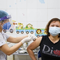 A woman receives a COVID-19 vaccine as Vietnam began its official rollout for health workers, at Hai Duong Hospital for Tropical Diseases in Hai Duong province, on March 8. | REUTERS