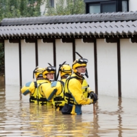 Police search a flooded area in the aftermath of Typhoon Hagibis, which caused severe floods at the Chikuma River in Nagano Prefecture in October 2019. | REUTERS