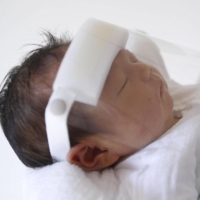 A mother holds her newborn baby at a hospital in Toyota, Aichi Prefecture, on May 28, 2020. | KYODO
