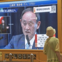 A large screen in Sapporo shows Prime Minister Yoshihide Suga speaking at a news conference in Tokyo on Thursday. | KYODO