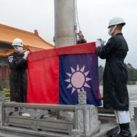 Honor guards raise a Taiwanese flag at the National Chiang Kai-shek Memorial Hall in Taipei on Wednesday. | BLOOMBERG