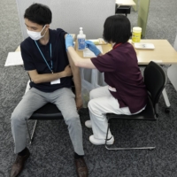 A Suntory Holdings employee receives a dose of the Moderna Inc. vaccine at the company's office in Tokyo on Monday.  | BLOOMBERG