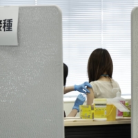 A Suntory Holdings Ltd. employee receives a dose of the Moderna COVID-19 vaccine at a vaccination site at the company's office in Tokyo on June 21. | BLOOMBERG