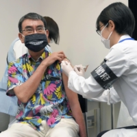 Taro Kono, the Cabinet minister in charge of the vaccine rollout, receives his first COVID-19 vaccination in Tokyo on Monday. | POOL / VIA KYODO