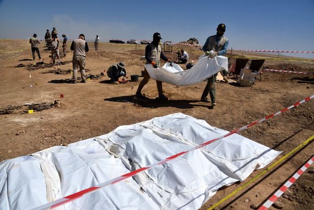 Iraqi forensic personnel work at a site believed to be a mass grave