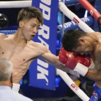 Naoya Inoue (left) attacks Michael Dasmarinas during their dual bantamweight title bout on Saturday in Las Vegas. | AP / VIA KYODO