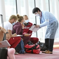 Members of the Danish Olympic rowing team fill in documents after their arrival at Tokyo's Haneda Airport on June 20. | KYODO