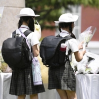 Students offer flowers at Ikeda Elementary School in Osaka Prefecture on Tuesday, the 20th anniversary of a stabbing rampage that killed eight pupils. | KYODO