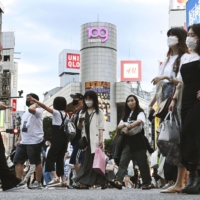 People walk at the scramble crossing near Tokyo's Shibuya Station on Thursday. | KYODO