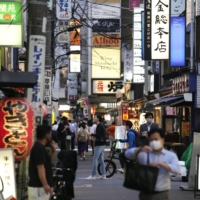 People walk in Tokyo's Shimbashi district on June 21 after a state of emergency was lifted in the capital. | KYODO