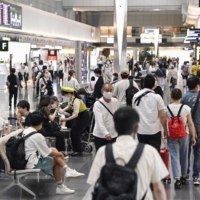 Travelers and visitors walk through Tokyo's Haneda Airport on Saturday morning. | KYODO