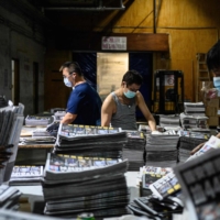 Employees compile different sections of freshly printed papers in the printing facility of the Apple Daily newspaper in Hong Kong on Friday.  | AFP-JIJI