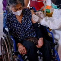 A health worker administers a dose of a COVID-19 vaccine in Banda Aceh, Indonesia, on Wednesday.  | AFP-JIJI