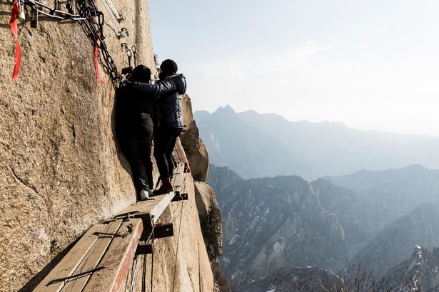 Hikers on the Mout Hua Shan cliff trail face sheer drops of 7,066ft