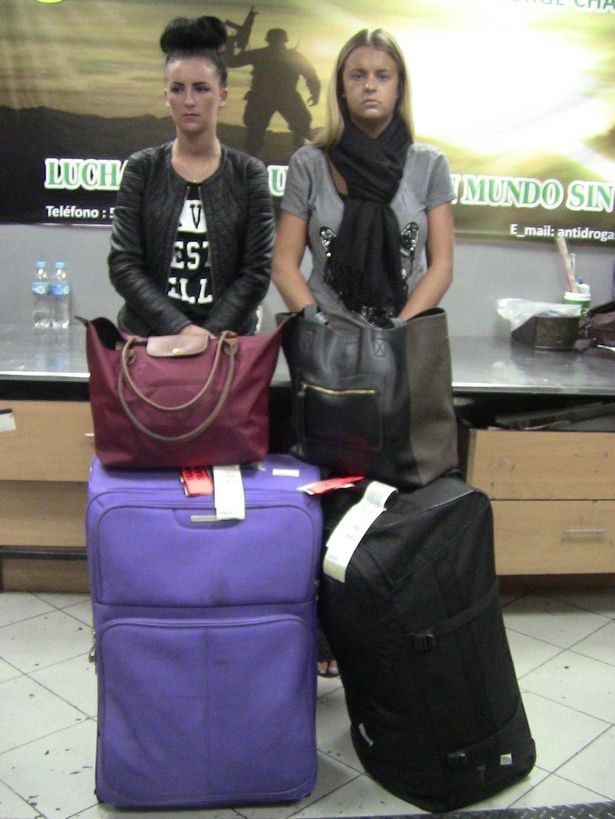 Michaella McCollum Connolly (L) and Melissa Reid stand together while being photographed by police after being arrested at the airport in Lima