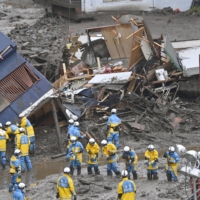 Rescue workers search for missing people in Atami, Shizuoka Prefecture, on Sunday. | KYODO