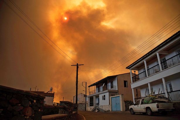 Heavy smoke covers the sky above the village of Ora in the southern slopes of the Troodos mountains, Cyprus