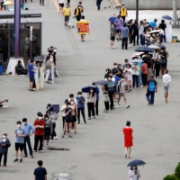 People wait in line for a COVID-19 test in Seoul on Wednesday.  | REUTERS