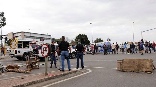 Residents block a road following protests that have widened into looting, in Durban