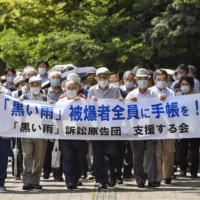 Plaintiffs who claim they should receive the same benefits as those provided for atomic bomb survivors walk to the Hiroshima High Court on Wednesday. | KYODO