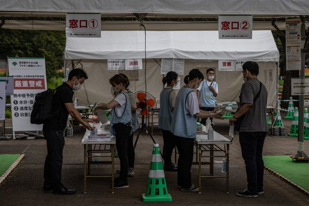 Tokyo residents arrive for jabs in an area that was due to be a Olympics fan park but has now been turned into a Covid vaccination site