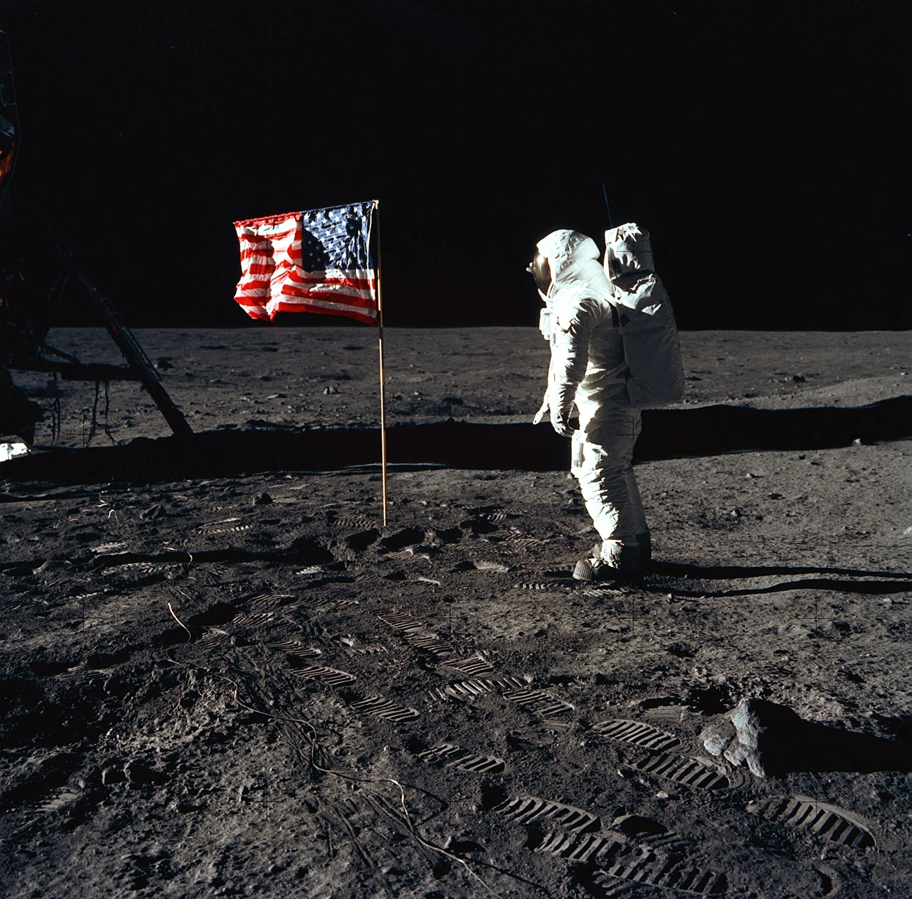 Astronaut poses for a photograph beside the deployed United States flag during an Apollo 11 extravehicular activity (EVA) on the lunar surface.(NASA)