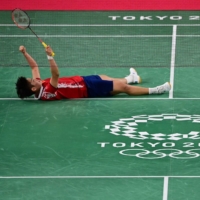 China's Huang Dongping celebrates after winning her mixed doubles badminton semifinal with Wang Yilyu against Japan's Arisa Higashino (right) and Yuta Watanabe at the Musashino Forest Sports Plaza in Tokyo on Thursday. | AFP-JIJI