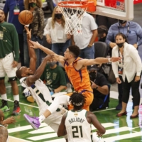 Bucks forward Khris Middleton shoots against Phoenix Suns guard Devin Booker during the fourth quarter during Game 4 of the NBA Finals at Fiserv Forum in Milwaukee, Wisconsin, on Wednesday. | USA TODAY / VIA REUTERS