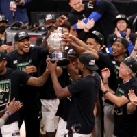 Milwaukee forward Khris Middleton holds up the Eastern Conference Finals trophy after the Bucks defeated the Hawks in Atlanta on Saturday. | USA TODAY / VIA REUTERS