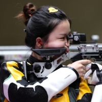 Yang Qian of China in action won the first gold medal of the Tokyo Olympics in the women's 10-meter Air Rifle competition on Saturday. | REUTERS