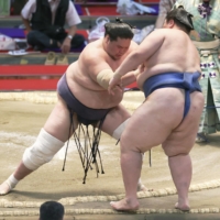 Terunofuji (left) shoves out Ichinojo during their bout at the Nagoya Grand Sumo Tournament on Friday. | KYODO