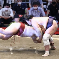 Terunofuji (right) brings down Takanosho during Day 3 of the Nagoya Basho at Dolphins Arena on Tuesday. | KYODO