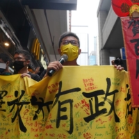 Pro-democracy protesters march in Hong Kong on Thursday during a demonstration near a flag-raising ceremony marking the 24th anniversary of the former British colony's return to Chinese rule. | REUTERS