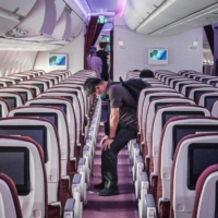 A passenger sits and waits to disembark from an aircraft at Haneda Airport on July 10. | AFP-JIJI