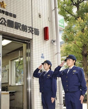 Reporting for duty: Two police officers give a salute in front of a police box in Tokyo's Daiba area. | KYODO