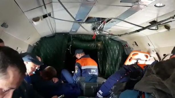 Rescuers aboard a helicopter involved in the search for the crashed An-26 plane