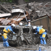 Police officers search for missing people in Atami, Shizuoka Prefecture, Sunday following a large mudslide triggered by torrential rain the previous day. | KYODO