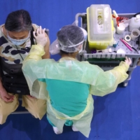 A medical worker administers a dose of the AstraZeneca COVID-19 vaccine to a woman during a vaccination session for elderly people over 75 years old, at a stadium in New Taipei City, Taiwan, on June 25. | REUTERS