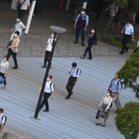 Workers walk from Kokusai-Tenjijo Station during the morning rush hour in Tokyo on Thursday. | REUTERS