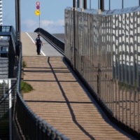 A police officer patrols the area outside the Athletes Village, where two athletes have tested positive for COVID-19, ahead of Tokyo 2020 Olympic Games, on Saturday. | REUTERS