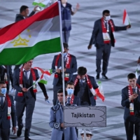 Athletes from the Tajikistan Olympic team, some maskless, take part in the Tokyo Games' opening ceremony on Friday.  | AFP-JIJI