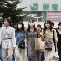 People walk in Tokyo's Shinjuku district on Wednesday. | KYODO