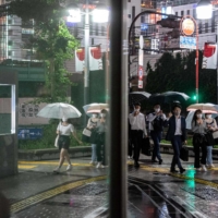 People walk on a street in Tokyo's Shinjuku district as Japan announces a new virus state of emergency stretching throughout the Tokyo Olympics on Thursday.  | AFP-JIJI