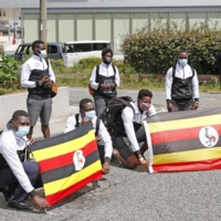 Members of Uganda's Olympic team pose for a photograph upon their arrival at their pre-Olympics camp host town in Izumisano, Osaka Prefecture, on June 20. | KYODO